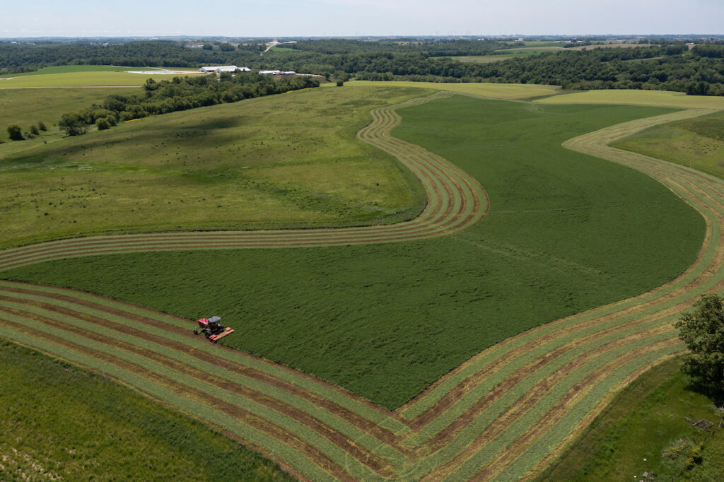 Steve Carpenter, owner of Redrock View farms near Darlington Wisconsin in Lafayette county, cutting hay in contours on public land set aside for farming near Darlington.